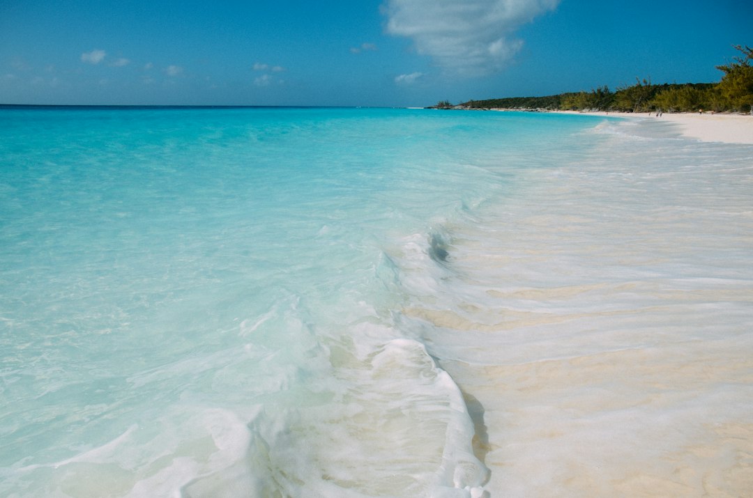Turquoise summer ocean waves on a white sand beach